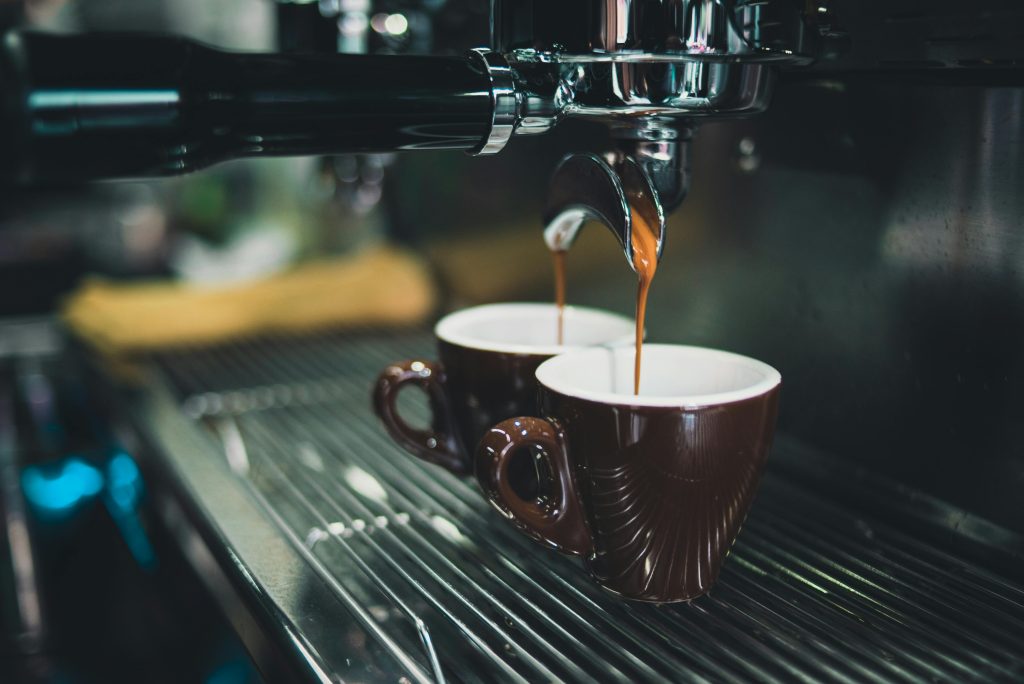 pexels-photo-324028-324028 Close-up of a professional espresso machine brewing coffee into cups.